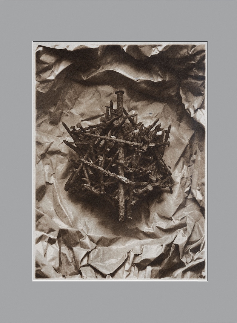 May include: A close-up of a pile of rusty nails arranged in a starburst pattern on a crumpled brown paper background.