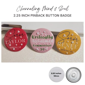 May include: Three round pinback button badges. One is red with the name "TAYLOR" and "SPRING '19". The second is pink with the words "Kritically Acclaimed Kommisioner" and the number "54". The third is yellow with the name "RENEE" and "SPRING '19". Each badge is 2.25 inches.