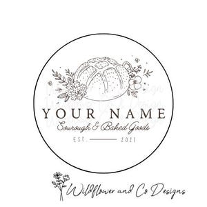 May include: Black and white logo design for a bakery called "YOUR NAME" Sourdough & Baked Goods. The logo features a round bread loaf with floral accents and the text "EST. 2021".