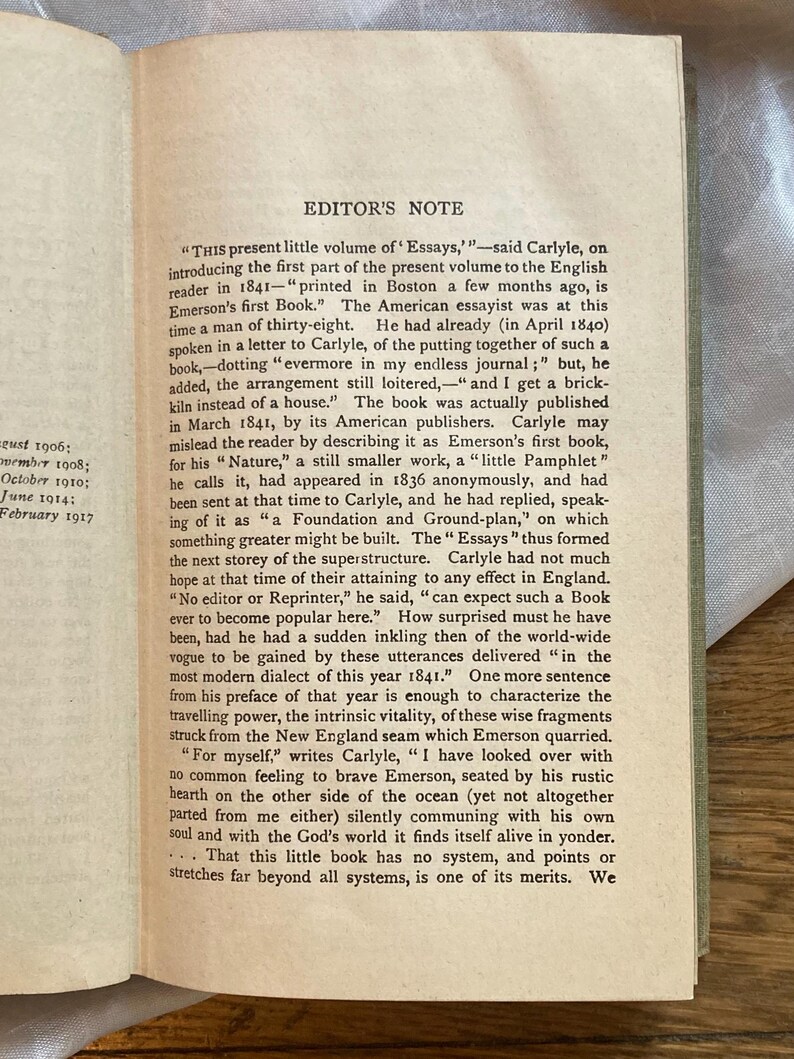 May include: Open book with text titled "EDITOR'S NOTE" and dates along the left side. The text is in black ink on aged, off-white paper. The text discusses the publication of Emerson's first book and Carlyle's thoughts on it.