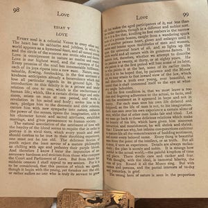 May include: Open book with text on aged paper, featuring the word "Love" at the top of the page. The book is open to two pages with text, and a decorative metal clasp is visible at the bottom.