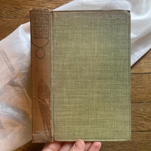 May include: Vintage book with a brown spine and a faded green cover. The spine features the title "Essays in First Series" by Ralph Waldo Emerson. The book is in good condition, with slight wear on the edges.