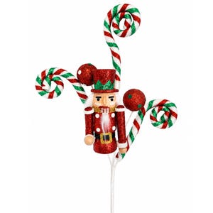 May include: A decorative nutcracker ornament featuring a red glittery uniform with a black belt and gold buckle. The figure is surrounded by three spiraled red and white candy cane stems and two red glittery spheres, all attached to a white stem.