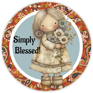 May include: A round illustration features a cartoon girl holding a bouquet of daisies. The girl wears a floral dress and boots. The text "Simply Blessed!" is written in black. The border has a paisley design in red, gold, and blue.