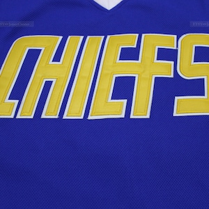 May include: A royal blue jersey with the word "CHIEFS" in yellow outlined in white.