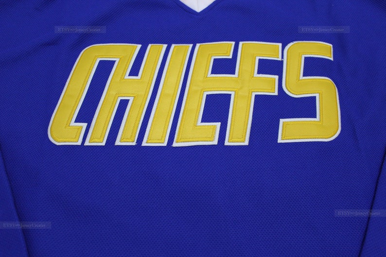 May include: A royal blue jersey with the word "CHIEFS" in yellow outlined in white.