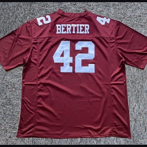 Puede incluir: Una camiseta de fútbol granate con letras blancas. La camiseta tiene el número "42" en la espalda y el nombre "Bertier" encima.