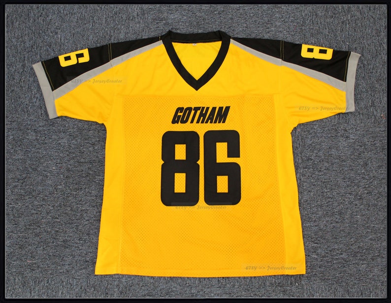 May include: Yellow football jersey with black and grey trim. The jersey has the word "GOTHAM" and the number "86" printed on the front.