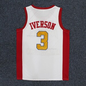 May include: White basketball jersey with red and gold accents. The jersey features the name "IVERSON" in red block letters above the number "3" in gold with a navy blue outline. The jersey has red side panels and trim.