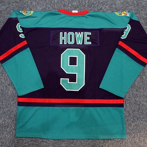 May include: A teal, purple, and red hockey jersey with the name "HOWE" and the number "9" on the back.