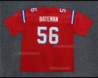 Puede incluir: Camiseta de fútbol roja con ribetes azules y blancos. La camiseta tiene el nombre "BATEMAN" y el número "56" en la espalda.