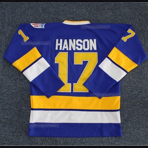May include: A blue hockey jersey with yellow and white stripes. The number "17" and the name "HANSON" are on the back of the jersey.