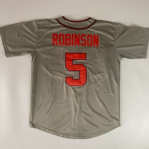 Puede incluir: Una camiseta de béisbol gris con el nombre "ROBINSON" y el número "5" impresos en la espalda en rojo.