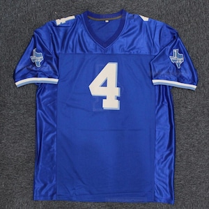 May include: A royal blue football jersey with the number 4 in white on the front. The jersey has a V-neck and white and light blue trim on the sleeves. Patches with text are on the sleeves.