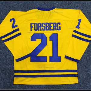 Könnte beinhalten: Gelbes Hockeytrikot mit blauen und weißen Streifen. Das Trikot trägt den Namen "FORSBERG" und die Nummer "21" auf der Rückseite.
