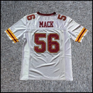 Könnte beinhalten: Weißes Footballtrikot mit burgunderroten und goldenen Akzenten. Die Nummer 56 befindet sich auf der Rückseite mit dem Namen "MACK" darüber.