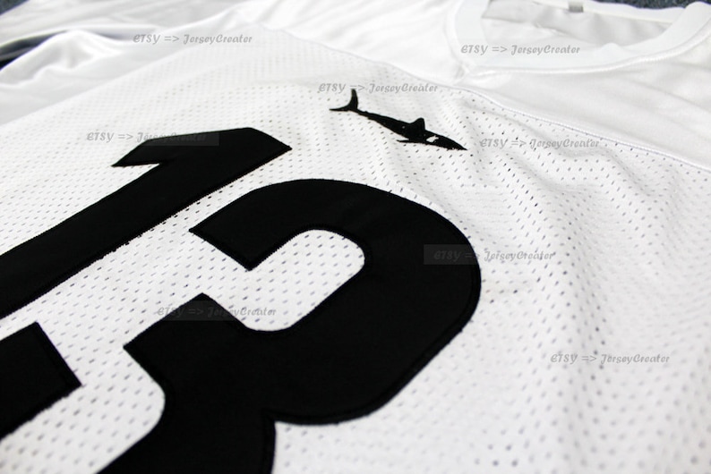 K&ouml;nnte beinhalten: Wei&szlig;es Mesh-Trikot mit einer schwarzen Nummer "13" auf der Vorderseite. Das Trikot hat ein schwarzes Hai-Logo oben links.