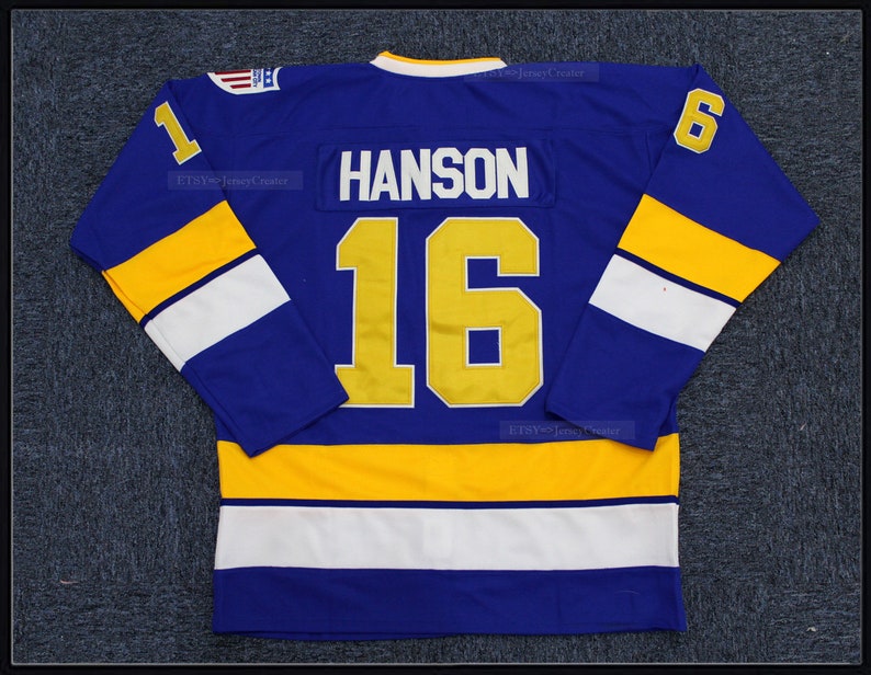 May include: A blue hockey jersey with yellow and white stripes. The number "16" and the name "HANSON" are printed on the back in gold.