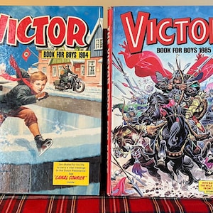 May include: Two vintage "Victor Book for Boys" magazines. The 1984 edition shows a boy ice skating, with text "Victor Book for Boys 1984". The 1985 edition depicts a battle scene with warriors and horses, with text "Victor Book for Boys 1985".