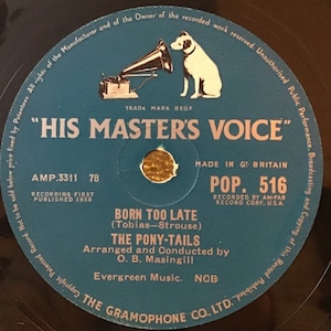 May include: A blue and white vinyl record with the text "His Master's Voice" and "Pop. 516" on it. The record is titled "Born Too Late" by "The Pony-Tails".