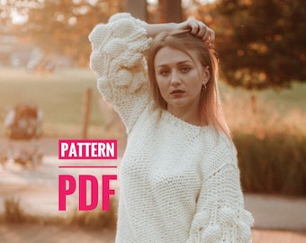 May include: Cream-colored, chunky knit sweater with bubble sleeves. The sweater is paired with black leather pants and boots. The image includes the text "PATTERN PDF".