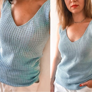 K&ouml;nnte beinhalten: Hellblaues Tanktop mit V-Ausschnitt und offenem Webmuster. Das Oberteil hat ein zartes, strukturiertes Muster und eine lockere Passform. Das &auml;rmellose Design und das leichte Material deuten auf ein Sommerkleidungsst&uuml;ck hin.