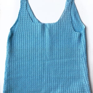 K&ouml;nnte beinhalten: Hellblaues H&auml;keltop mit rundem Ausschnitt und breiten Tr&auml;gern. Das Oberteil hat ein strukturiertes, offen gewebtes Design. Das Kleidungsst&uuml;ck wird auf wei&szlig;em Hintergrund pr&auml;sentiert. Dieses handgefertigte Top ist perfekt f&uuml;r warmes Wetter.