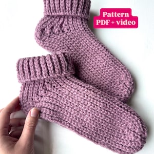 Może przedstawiać: Para dzianych skarpet w kolorze przydymionego różu. Skarpetki mają ściągacz i wzorzysty ścieg. Obraz zawiera tekst "Pattern PDF + video".