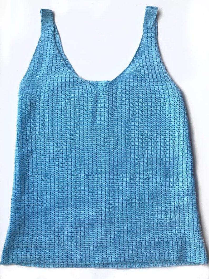 K&ouml;nnte beinhalten: Hellblaues H&auml;keltop mit V-Ausschnitt und breiten Tr&auml;gern. Das Oberteil hat ein strukturiertes, offenes Webmuster. Das Kleidungsst&uuml;ck besteht aus einem weichen, atmungsaktiven Material, ideal f&uuml;r warmes Wetter. Das Tanktop ist ein l&auml;ssiger, bequemer Stil.