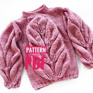 May include: A dusty rose knitted sweater and matching hat with a leaf pattern. The sweater has a high neck and voluminous sleeves. The text "PATTERN PDF" is overlaid on the image.