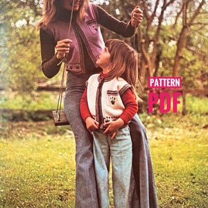 Op de afbeelding: Een vintage afbeelding toont een vrouw en een kind die bijpassende gebreide vesten dragen. De vesten zijn paars en crème met decoratieve randen. De vrouw draagt een top met lange mouwen en een spijkerbroek. Het kind draagt een rood shirt met lange mouwen en een spijkerbroek. De tekst "PATTERN PDF" is zichtbaar.
