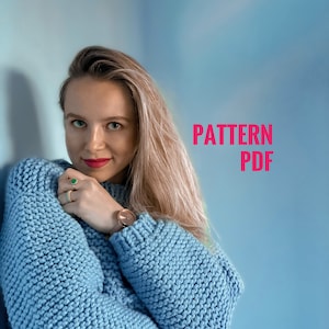 May include: A light blue, chunky knit sweater with the text "PATTERN PDF" in pink. The sweater has a crew neck and long sleeves. The background is a gradient of blue and white.