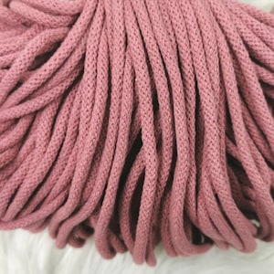 Könnte beinhalten: Nahaufnahme eines Bündels rosa Baumwollkordel. Die Kordel ist weich und texturiert und perfekt für Bastelprojekte.