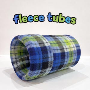 May include: A blue, green, and white plaid fleece tube for small pets. The words "fleece tubes" are written above the tube in blue and green bubble letters. The tube is cylindrical and appears soft.