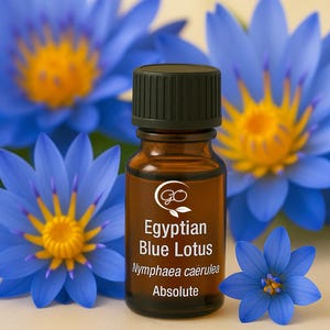 May include: A brown glass bottle with a black cap, labelled "Egyptian Blue Lotus" and "Nymphaea caerulea Absolute." The bottle is set against a backdrop of vibrant blue lotus flowers with yellow centres. The image is well-lit and focuses on the essential oil.