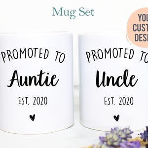 May include: Two white ceramic mugs featuring black text. The left mug reads PROMOTED TO Auntie EST. 2020 with a small heart. The right mug reads PROMOTED TO Uncle EST. 2020 with a small heart. A circular graphic in the top right corner says YOUR CUSTOM DESIGN.