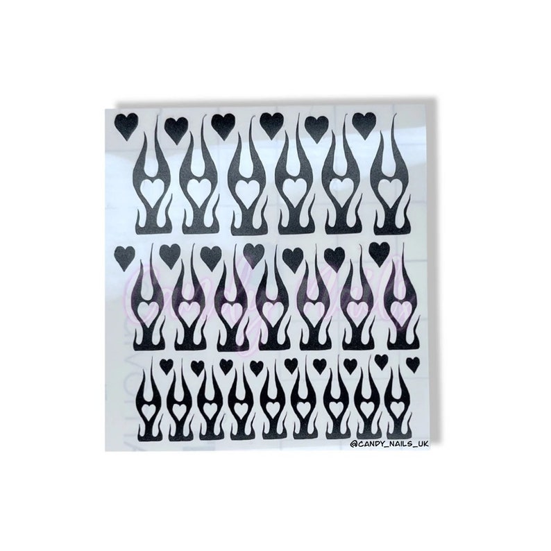 Puede incluir: Calcoman&iacute;as para u&ntilde;as en blanco y negro con un dise&ntilde;o de llama y un coraz&oacute;n en el centro de cada llama. Las calcoman&iacute;as est&aacute;n dispuestas en filas sobre una hoja transparente. El texto "@CANDY_NAILS_UK" est&aacute; en la esquina inferior derecha.