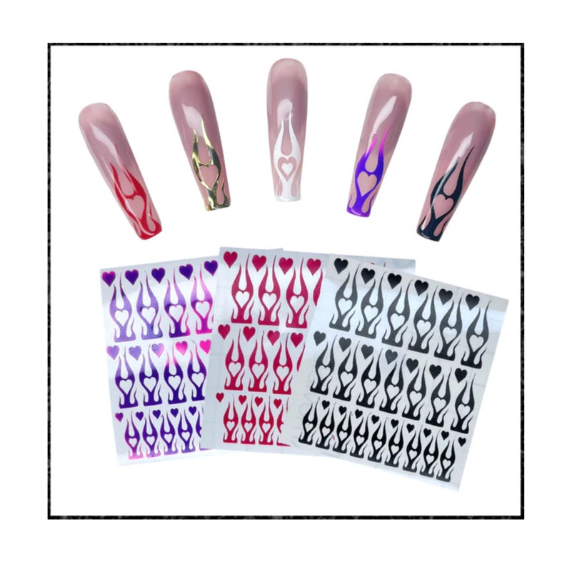 Puede incluir: Pegatinas para u&ntilde;as con un dise&ntilde;o de llama y un coraz&oacute;n en el centro. Las pegatinas est&aacute;n disponibles en morado, rojo y negro.