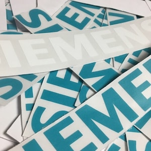Może przedstawiać: Kolekcja białych naklejek z napisem "SIEMENS" w turkusowym kolorze. Naklejki są rozrzucone na białej powierzchni, niekt&oacute;re zachodzą na siebie.