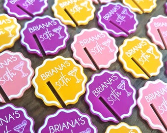 May include: A collection of colorful round drink markers with the text "Briana's 30th" in white. The markers are in yellow, pink, and purple with a white outline. Each marker has a small martini glass design.