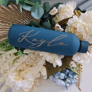 Könnte beinhalten: Eine blaugrüne Wasserflasche mit dem Namen "Kayla" in silbernen Lettern graviert.