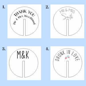 Puede incluir: Cuatro tarjetas de mesa circulares blancas con una ranura para un tallo. Las tarjetas presentan texto negro: "THANK YOU Mr & Mrs Woodland", "MR & MRS Smith", "M&K" y "DRUNK IN LOVE" con copas de vino.
