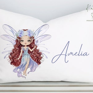May include: White pillowcase with a blue fairy illustration and the name Amelia in purple script.