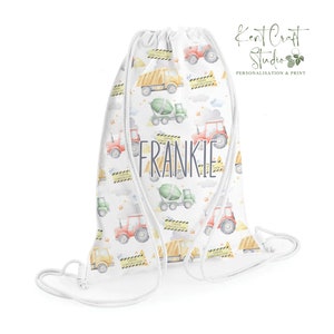 May include: White drawstring bag with a construction theme. The bag is covered in a repeating pattern of construction vehicles, including dump trucks, cement mixers, and tractors. The bag is personalized with the name "FRANKIE" in gray text.