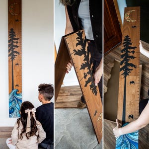 Peut inclure: Toise en bois avec un motif d'arbre et de vagues. La toise présente une silhouette d'arbre noire, un croissant de lune et des vagues bleues et blanches. Les mesures sont en centimètres, avec une hauteur maximale de 152 cm.