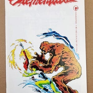 May include: Comic book cover featuring the title "Elementals" in red script. The artwork depicts several costumed figures in action, including a large, orange, rock-like character and figures with water and fire-based powers. The comic is on a white background.