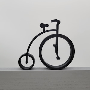 Puede incluir: Silueta negra de una bicicleta vintage con una rueda delantera grande y una rueda trasera pequeña. La bicicleta está hecha de metal y tiene un diseño simple.