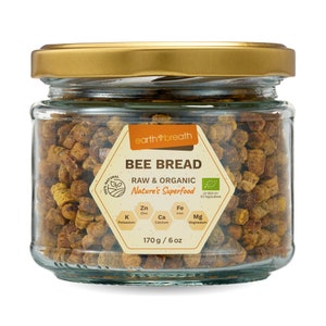 Może przedstawiać: Szklany słoik ze złotą pokrywką wypełniony chlebem pszczelim. Etykieta zawiera napis "earth breath BEE BREAD RAW & ORGANIC Nature's Superfood LV-BIO-01 EU Agriculture" i podaje wartości odżywcze: "Zn Cynk, Fe Żelazo, K Potas, Ca Wapń, Mg Magnez". Słoik zawiera 170 g / 6 oz chleba pszczelego.
