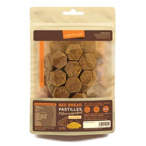 May include: A resealable bag of bee bread pastilles, a natural superfood with pollen. The pastilles are hexagonal and brown in colour. The bag is labelled "Bee Bread Pastilles, Nature's Superfood with Pollen".