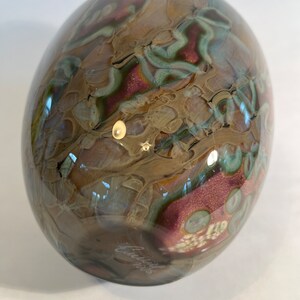 Pu&ograve; includere: Una sfera di vetro marrone, verde e rosa con motivi a spirale. La sfera &egrave; firmata "Chihuly" sul fondo.